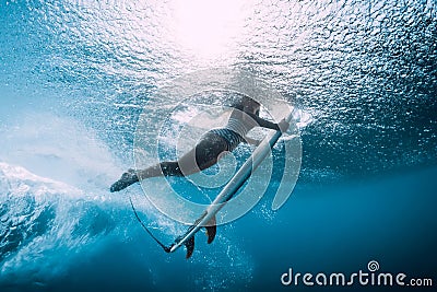 Surfer woman dive underwater. Surfgirl dive under wave Stock Photo