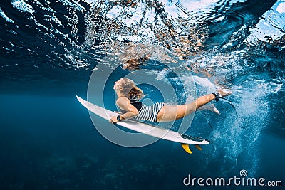 Surfer woman dive underwater. Surfgirl dive under wave Stock Photo