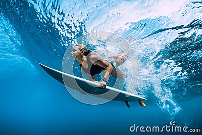 Surfer woman dive underwater. Surfgirl dive under wave Stock Photo