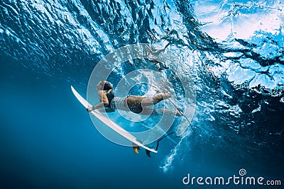 Surfer woman dive underwater. Surfgirl dive under wave Stock Photo