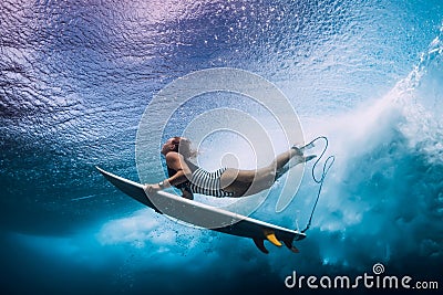 Surfer woman dive underwater. Surfgirl dive under wave Stock Photo