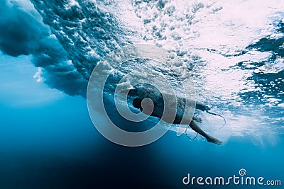 Surfer woman dive underwater. Surfgirl dive under wave Stock Photo
