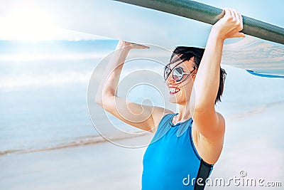 Surfer woman with longboard going into ocean waves. Active vacation concept image Stock Photo