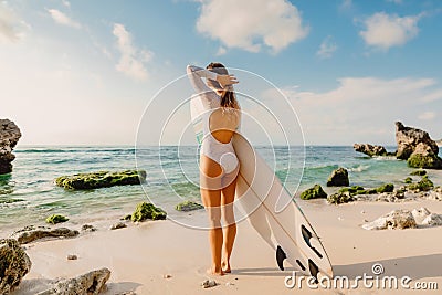 Surfer woman with surfboard. Surfing in ocean Stock Photo
