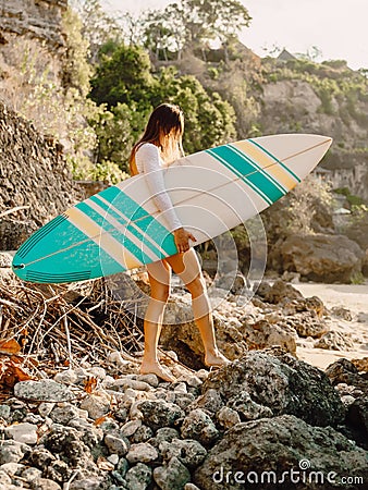 Surfer woman with surfboard. Surfing in ocean Stock Photo