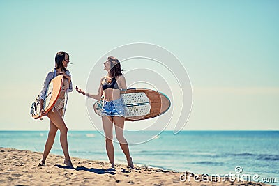 Surfers on beach having fun in summer. Smiling girls with a surf Stock Photo