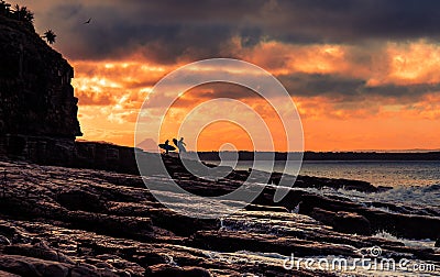 Surfers on shore in sunset time Stock Photo