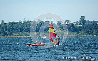 Surfers swimming on boards on the Puck Bay in poland on a warm summer day Editorial Stock Photo