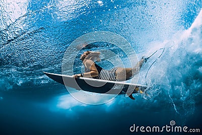 Surfgirl with surfboard dive underwater with under ocean wave Stock Photo