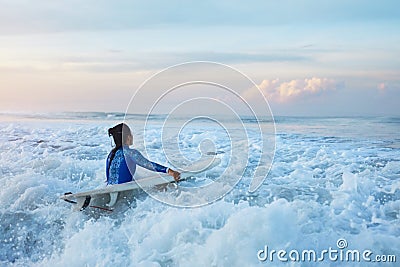 Surfing Girl. Surfer With Surfboard Swimming In Ocean. Brunette In Blue Wetsuit Going To Surf In Splashing Sea. Stock Photo