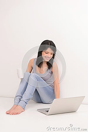 Surfing web and drinking coffee. Beautiful young woman using com Stock Photo