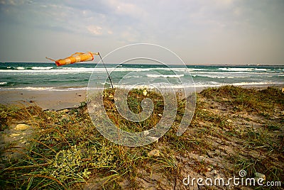 Surfing wind-sock on empty sea beach during storm Stock Photo