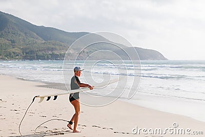 Surfing woman with surfing board on the beach Stock Photo
