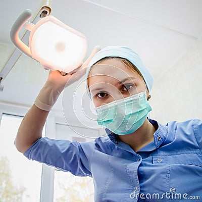 The surgeon dentist in mask holding forceps preparing for tooth extraction at clinic Stock Photo