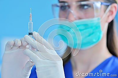 The surgeon dentist in mask holding syringe for injecting anesthesia. Stock Photo