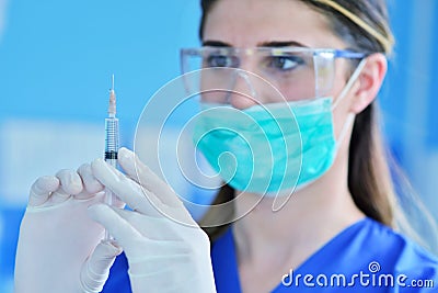 The surgeon dentist in mask holding syringe for injecting anesthesia. Stock Photo