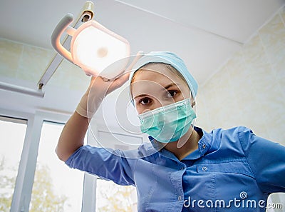 The surgeon dentist in mask leaned over patient for dental checkup at clinic Stock Photo