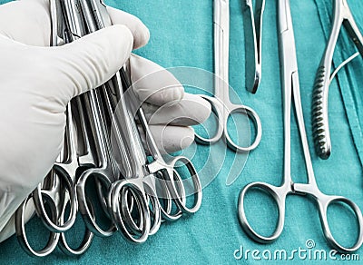 Surgeon working in operating room, hands with gloves holding scissors sutures Stock Photo