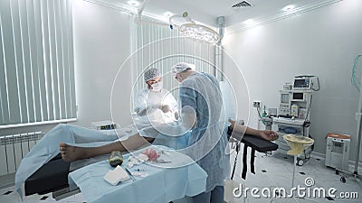 Surgeons perform operation under anesthesia. Action. Two professional surgeons perform operation under anesthesia in Stock Photo