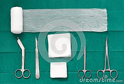 surgery tools ,scissors ,roll gauze,bandage,pad,cramp,blade,knife on green surgical dress background ,bird eye view Stock Photo