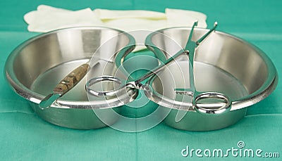 Surgical clamp and knife placed on kidney shape bowl Stock Photo