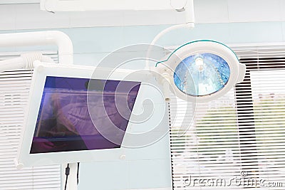 Surgical lamp in dental operating room, monitor with x-ray of jaw Stock Photo