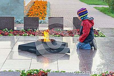 SURGUT, RUSSIA - SEPTEMBER 2, 2018: Boy at the eternal flame of the soviet soldier Editorial Stock Photo