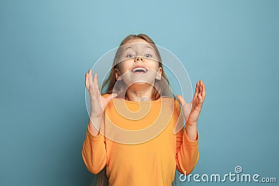 The surprise, happiness, joy, victory, success and luck. Teen girl on a blue background. Facial expressions and people Stock Photo