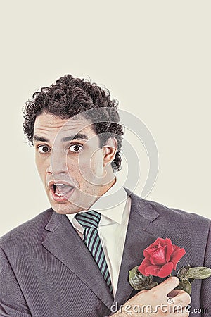 Surprised afraid man in suit trying to avoid and escape rose Stock Photo