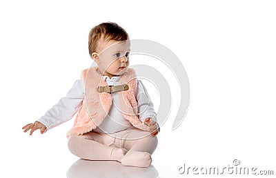 Surprised baby girl in warm clothes sit on floor Stock Photo