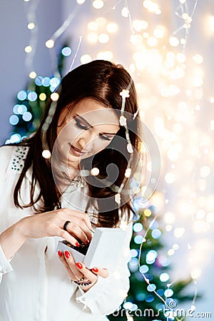 Surprised beautiful young woman holding an open jewelry gift box. Stock Photo