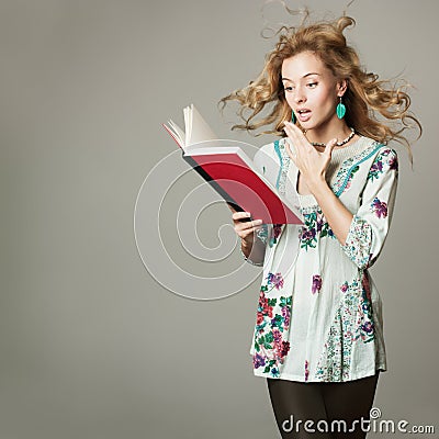 Surprised Blonde Woman Reading a Book Stock Photo