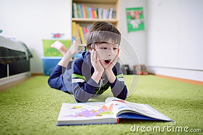 Surprised boy is discovering something from the book Stock Photo