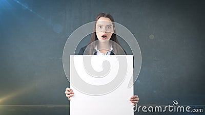 Surprised Business woman portrait with blank white board on gray isolated . Female model with long hair. Stock Photo