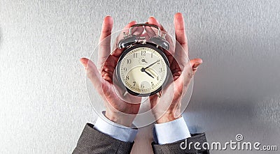 Surprised businessman hands holding an alarm clock for time strategy Stock Photo