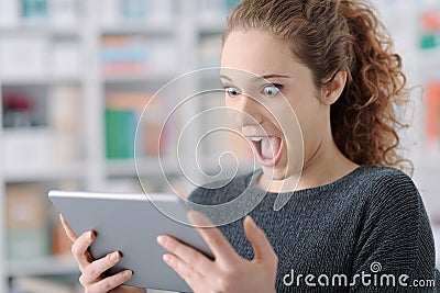 Surprised cheerful girl connecting with her tablet Stock Photo