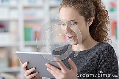 Surprised cheerful girl connecting with her tablet Stock Photo