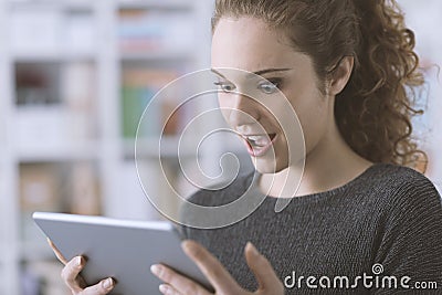 Surprised cheerful girl connecting with her tablet Stock Photo