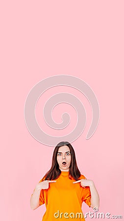 Surprised and Confident: Young Woman Expressing Astonishment and Self-Assurance, Pointing Two Fingers at Herself Stock Photo