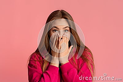 Surprised girl closes her mouth with hands Stock Photo