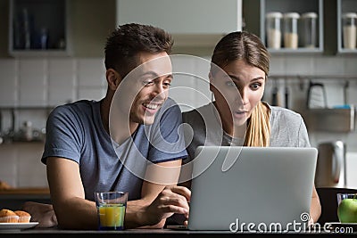 Surprised couple amazed with online shopping sale looking at lap Stock Photo