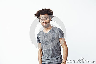 Surprised displeased african man looking at camera over white background. Copy space. Stock Photo