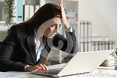 Surprised executive discovering mistake on laptop at office Stock Photo