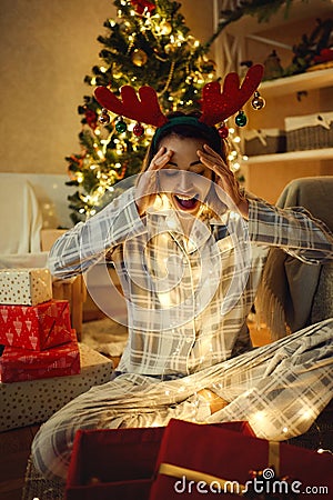 Surprised festive woman receive large present on Christmas time Stock Photo