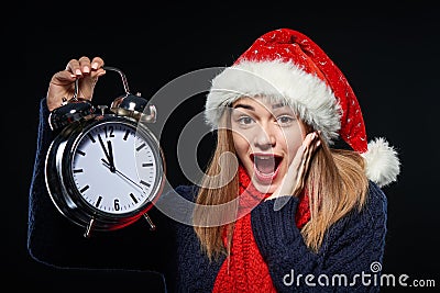 Surprised girl in Santa hat with alarm clock Stock Photo