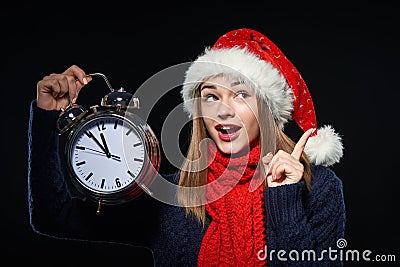 Surprised girl in Santa hat with clock Stock Photo