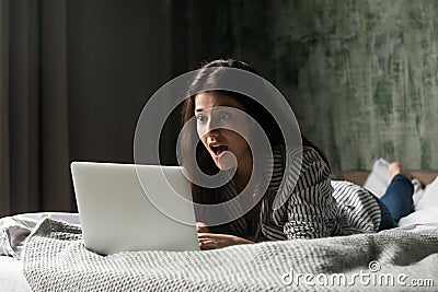 Surprised girl shocked receiving unexpected message at laptop Stock Photo