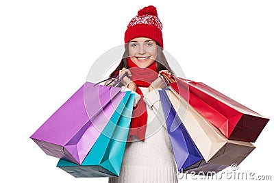 Surprised happy beautiful woman holding shopping bags in excitement. Christmas girl on winter sale, isolated on white background Stock Photo