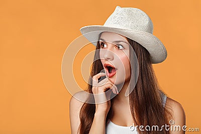 Surprised happy beautiful woman looking sideways in excitemen, isolated on orange background Stock Photo