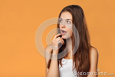 Surprised happy beautiful woman looking sideways in excitement. on orange background Stock Photo